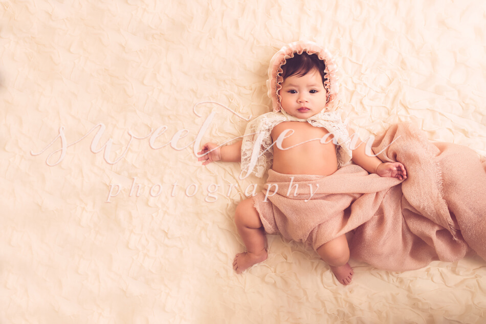 baby girl in pink bonnet