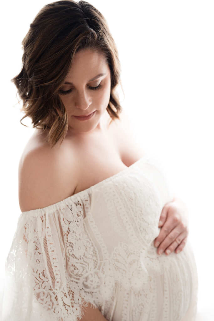 Backlit maternity portrait wearing an off shoulder lace gown by Sacramento studio maternity photographer Sweet Jean Photography. photo