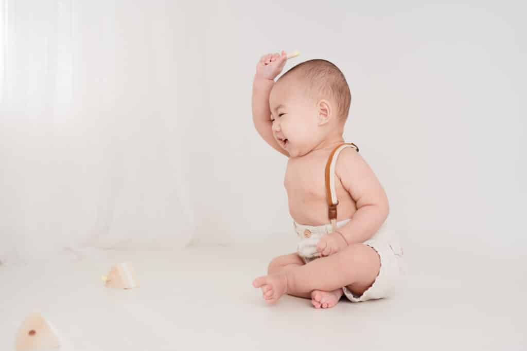 Sacramento baby photographer Sweet Jean captures baby boy playing with wooden toys for his 1st birthday session.